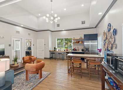 A modern open plan living and kitchen area with wooden floors and furniture.