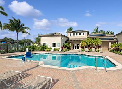 A pool with a blue chair and a house in the background.