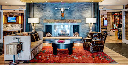 A living room with a fireplace and a rug.