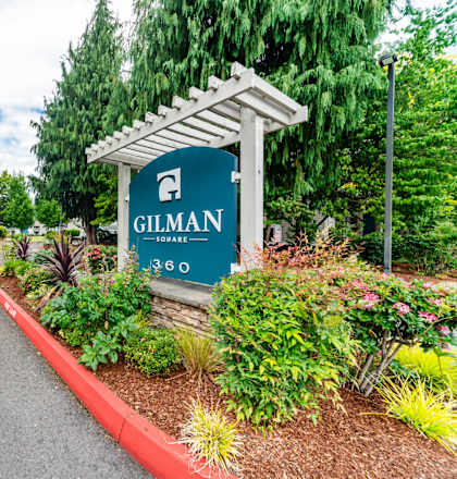 A sign that says Gilman is in front of a building.