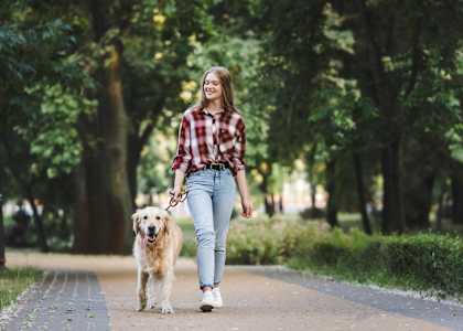 a woman walking her dog in a park