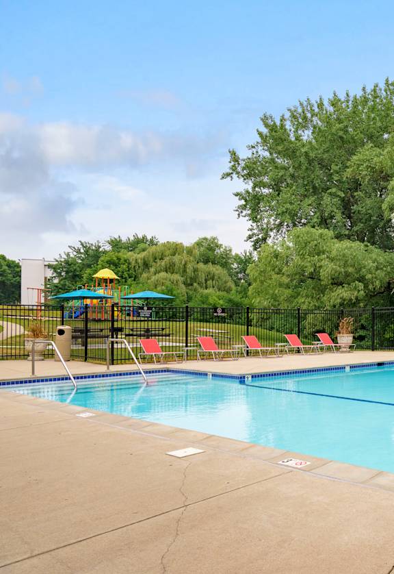 a swimming pool with a gazebo and lounge chairs  at Willow Pond, Burnsville