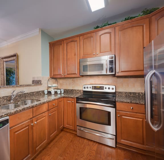 Kitchen with Wooden Cabinets at The Cosmopolitan at Lorton Station in Lorton, VA