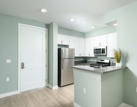 a kitchen with white cabinets and a stainless steel refrigerator