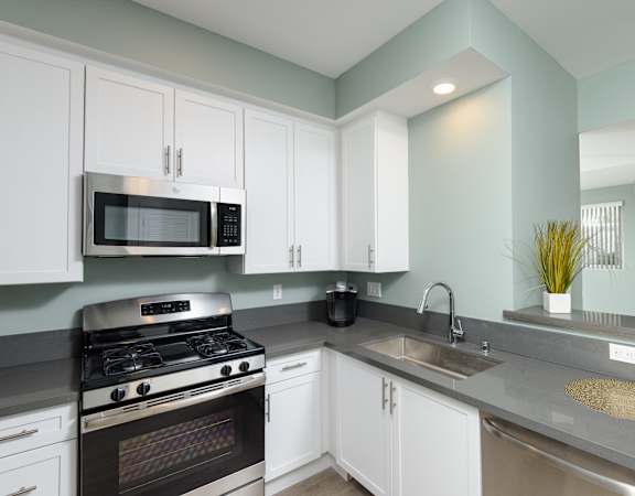 a kitchen with stainless steel appliances and white cabinets