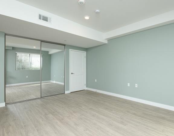 an empty room with a sliding glass door and a hard wood floor