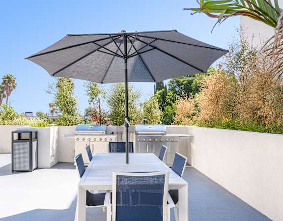 a patio with a table and chairs and an umbrella