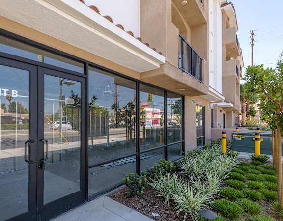 the entrance to a building with glass doors and a sidewalk