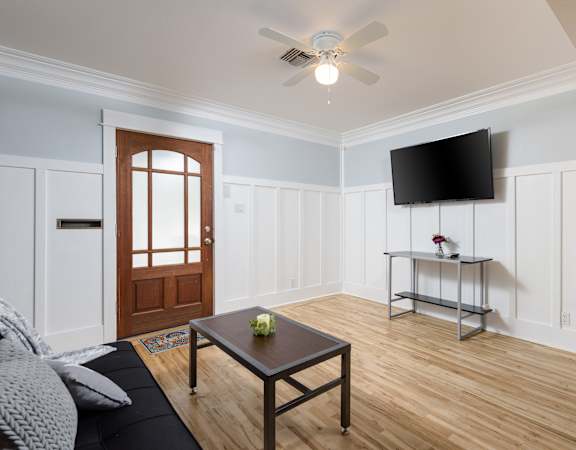 a living room with a coffee table and a tv on the wall