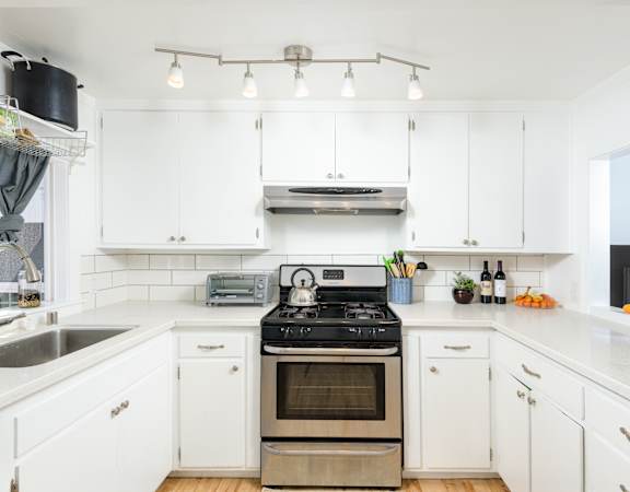 a kitchen with white cabinets and stainless steel appliances