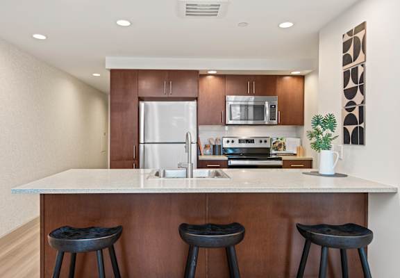 A kitchen with a white countertop and brown cabinets.