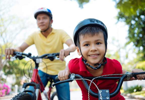 a boy riding a bike with a man on a bike
