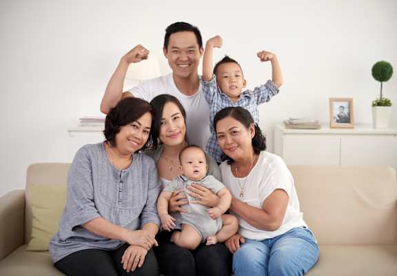 A family of five sitting on a couch in a living room.