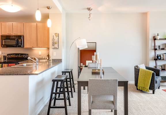 A kitchen with a table and chairs in the middle of the room at The Grand Apartments, Oakland, CA, 94612
