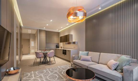 A modern living room with a grey couch and a round table.