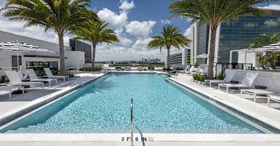 a swimming pool at a hotel with palm trees