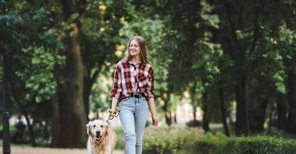 a woman walking her dog in a park
