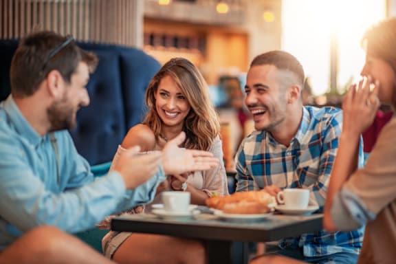 a group of people sitting around a table talking