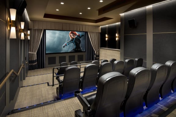 a large auditorium with a row of chairs and a projector screen