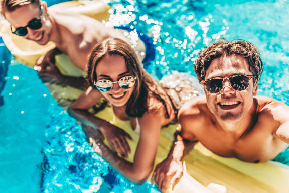 a group of people in a swimming pool wearing sunglasses