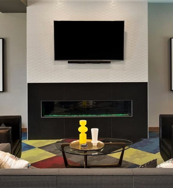 A black TV mounted above a fireplace in a living room at Era on Excelsior, St. Louis Park, Minnesota