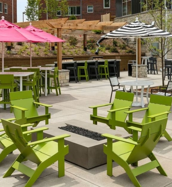 A patio with green chairs and tables. at Era on Excelsior, St. Louis Park, Minnesota