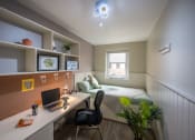 Thumbnail 5 of 8 - a bedroom with a bed and a desk with a laptop
