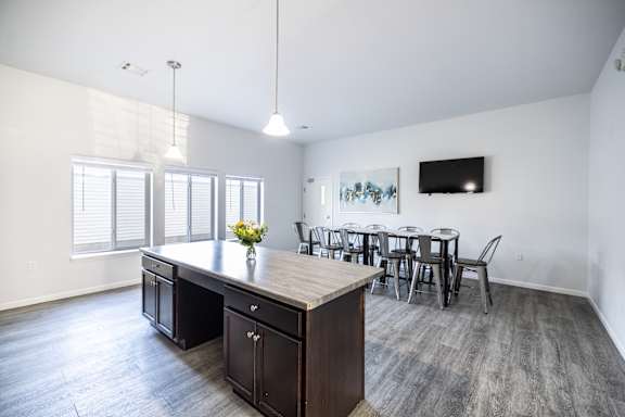 A kitchen with a table and chairs in front of a window.