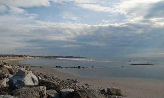 a beach with rocks and the ocean with a cloudy sky at Beverly Village for Living & the Arts Apartments, Massachusetts, 01915
