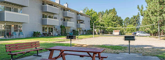 a picnic table with a grill in a yard  at Ironwood Apartments, Coeur d'Alene, ID