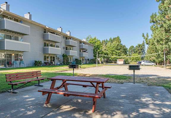 A red picnic table is in the middle of a concrete patio at Ironwood Apartments, Coeur d'Alene, Idaho