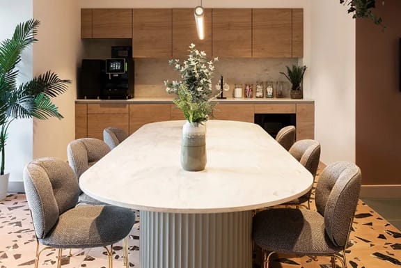 a dining room table with a vase of flowers on it