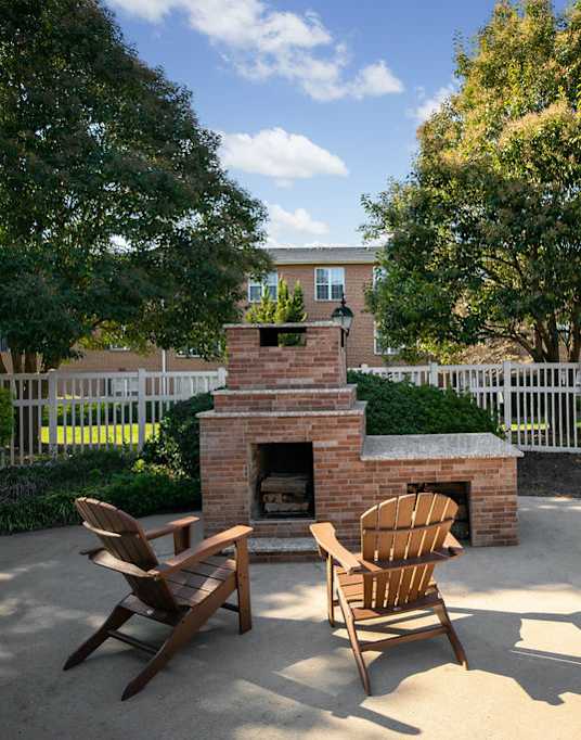 A backyard with a fireplace and chairs.