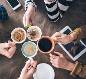 a group of people holding cups of coffee