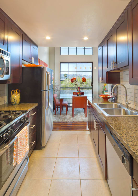 A kitchen with a refrigerator and stove top oven.