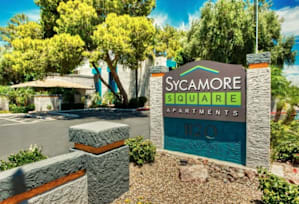 A sign for Sycamore Square Apartments is in front of a tree. at Sycamore Square  Apartments, Arizona, 85202