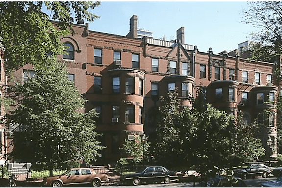 A brown building with a tree in front of it.
