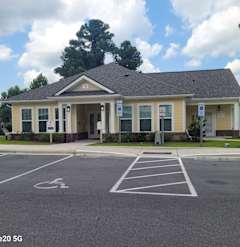 the front of a building with a parking lot in front of it