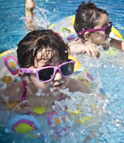 a couple of kids are swimming in a pool