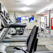 A gym with treadmills, exercise bikes, and weight machines.