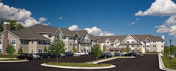 A large building with a parking lot in front.