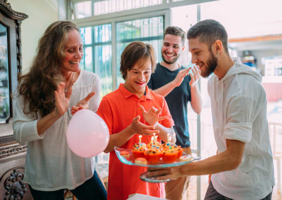 a group of people celebrating a birthday party with a cake