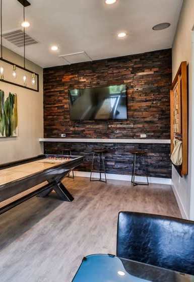 A room with a pool table and a bar area.