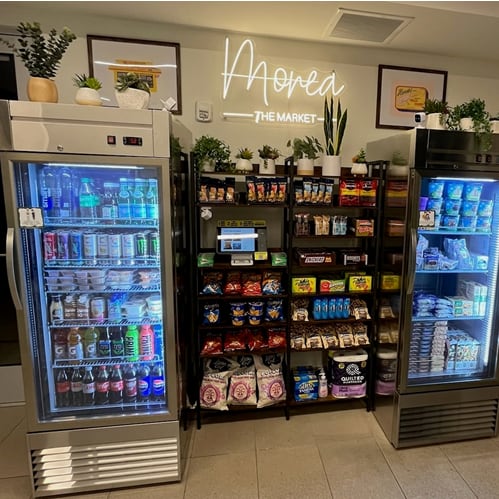 two refrigerators in the lobby of a store filled with drinks