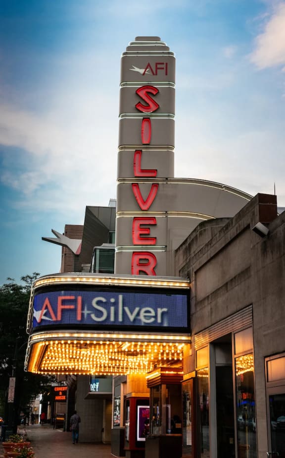 the neon sign for the afl silver theatre at dusk