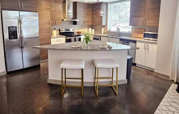 a large kitchen with stainless steel appliances and a marble counter top