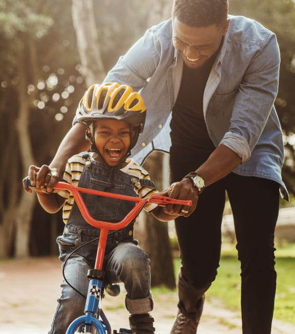 a man helping a young boy ride a bike