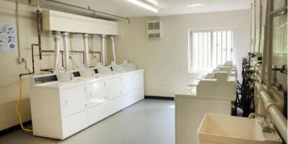 a large room with white appliances and sinks in it