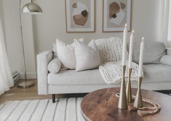 a living room with a couch and a table with candles