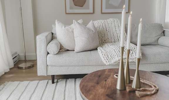 a living room with a couch and a table with candles